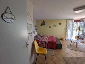 sypialnia z czerwonym łóżkiem i żółtym krzesłem w obiekcie Guestroom Bruyères, 1 pièce, 2 personnes - FR-1-589-602 w mieście Bruyères