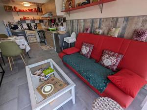 salon z czerwoną kanapą i stołem w obiekcie Guestroom Bruyères, 1 pièce, 2 personnes - FR-1-589-602 w mieście Bruyères