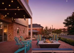 een groep stoelen en een vuurplaats op een patio bij Home2 Suites By Hilton Tupelo in Tupelo