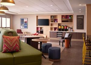 uma sala de espera com um sofá verde e uma mesa em Home2 Suites By Hilton Tupelo em Tupelo
