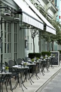 eine Reihe von Tischen und Stühlen auf einer Terrasse in der Unterkunft Charlotte Street Hotel, Firmdale Hotels in London