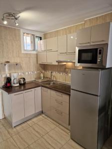 a kitchen with a stainless steel refrigerator and a microwave at Eldorado Casa Gi in Playa de las Americas