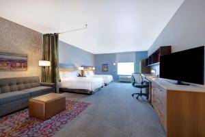 a hotel room with a bed and a flat screen tv at Home2 Suites By Hilton Las Vegas Northwest in Las Vegas