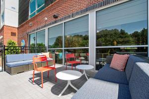 a patio with a couch and chairs and tables at Tru By Hilton Chapel Hill in Chapel Hill