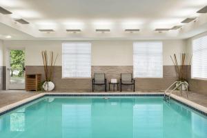 卡萊爾的住宿－Homewood Suites By Hilton Carlisle，游泳池位于酒店客房内,配有两把椅子和一张桌子