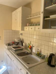logement complet 2 chambres garage wifi de 1 a 5 voyageurs في Montfort-le-Gesnois: طاولة مطبخ مع حوض ومرآة