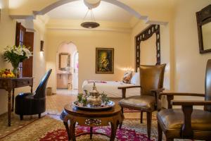 a living room with a bed and a table at Demeures d'Orient Riad & Spa in Marrakesh