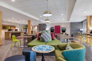 a lobby with a green couch and tables and chairs at Home2 Suites By Hilton Wilkes-Barre in Wilkes-Barre