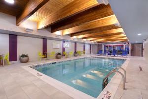 a large swimming pool in a building with yellow chairs at Home2 Suites By Hilton Wilkes-Barre in Wilkes-Barre
