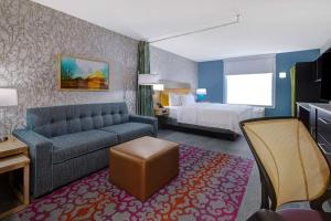Habitación de hotel con sofá y cama en Home2 Suites By Hilton Wilkes-Barre en Wilkes-Barre