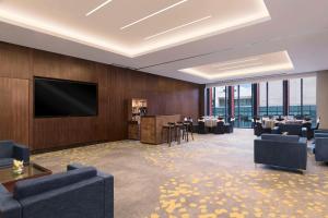 a dining room with tables and a flat screen tv at Hilton Bengaluru Embassy Manyata Business Park in Bangalore