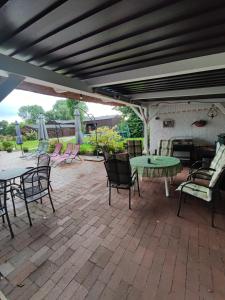 a patio with a table and chairs and a fire place at Haus am Fluß in Oberndorf