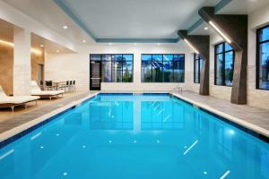 a swimming pool with blue water in a house at Embassy Suites By Hilton Atlanta Airport North in Atlanta