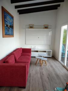 バルパライソにあるMaitencillo Cerca de la Playaのリビングルーム(赤いソファ、テーブル付)