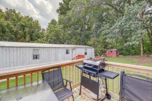 a bbq grill on a deck with a fence at Creekfront Max Meadows Mobile Home with Deck! in Max Meadows