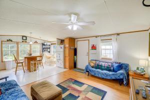 een woonkamer met een blauwe bank en een tafel bij Creekfront Max Meadows Mobile Home with Deck! in Max Meadows