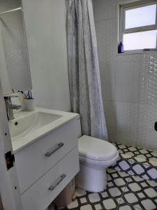 バルパライソにあるMaitencillo Cerca de la Playaのバスルーム(洗面台、トイレ付)、窓が備わります。