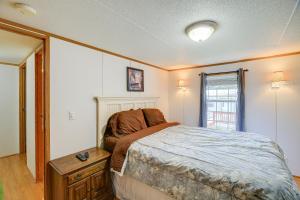 a bedroom with a large bed and a window at Creekfront Max Meadows Mobile Home with Deck! in Max Meadows