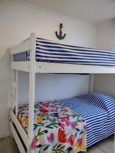 バルパライソにあるMaitencillo Cerca de la Playaのベッドルーム1室(花柄のベッドシーツ付きの二段ベッド1組付)