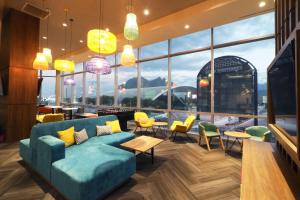 a lobby with a blue couch and chairs and windows at Tru By Hilton Monterrey Fundidora in Monterrey