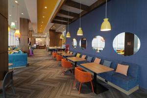 un restaurant avec des tables, des chaises et des miroirs dans l'établissement Tru By Hilton Monterrey Fundidora, à Monterrey
