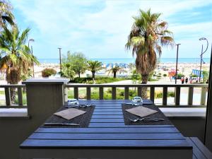 a table on a balcony with a view of the beach at Yes Hotel Touring & SPA in Rimini
