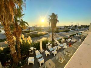 a view of a patio with white chairs and palm trees at Yes Hotel Touring & SPA in Rimini