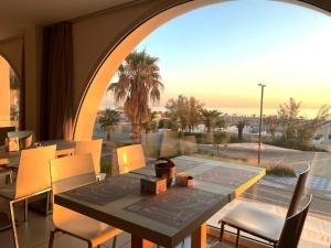 a dining room with a table and chairs and a large window at Yes Hotel Touring & SPA in Rimini