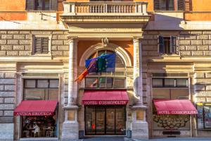 a store front with red awnings on a building at Cosmopolita Hotel Rome, Tapestry Collection by Hilton in Rome