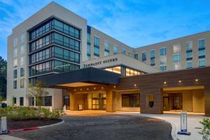 an office building with a parking lot in front of it at Embassy Suites By Hilton Alpharetta Halcyon in Alpharetta