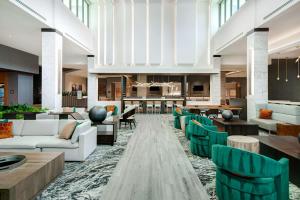 a lobby with couches and chairs and a bar at Embassy Suites By Hilton Alpharetta Halcyon in Alpharetta