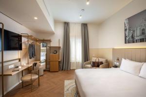 a hotel room with a bed and a desk at Cosmopolita Hotel Rome, Tapestry Collection by Hilton in Rome