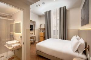 una camera d'albergo con letto e lavandino di Cosmopolita Hotel Rome, Tapestry Collection by Hilton a Roma