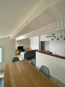 ein Wohnzimmer mit einem Holztisch und Stühlen in der Unterkunft Duplex de charme avec terrasses in Nîmes