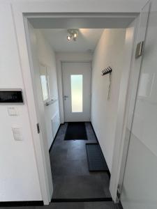 um corredor com paredes brancas e uma porta branca em Ferienwohnung Strobel em Niedereschach