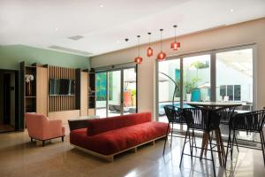 Hampton by Hilton Veracruz Boca Del Rio في فيراكروز: غرفة معيشة مع أريكة حمراء وطاولة
