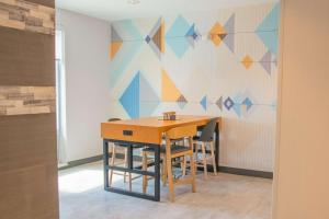 a table and chairs in a room with a colorful wall at Home2 Suites By Hilton Logansport in Logansport