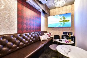 a bar with a brown leather couch and two tables at Hotel Bali An Resort Shinsaibashi in Osaka