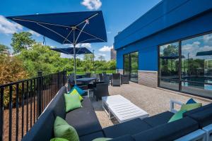 a patio with couches and tables and an umbrella at Hampton Inn by Hilton Detroit Southfield in Southfield