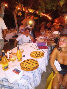 un grupo de personas sentadas alrededor de una mesa con comida en Poggio agli Ulivi, en Frascati