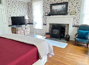 1 dormitorio con chimenea, 1 cama y TV en Historic Seaton Springs Farm B&B - J Seaton King Room & Private Bath en Sevierville