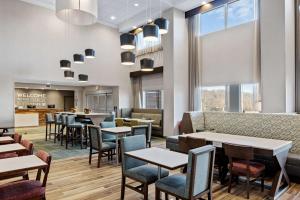 un ristorante con tavoli e sedie e un bar di Hampton Inn & Suites Cincinnati West, Oh a Dent