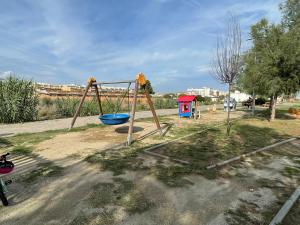 un parque infantil con columpios en Cunit Beach, en Cunit