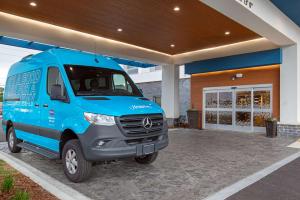 ein blauer Van vor einem Gebäude geparkt in der Unterkunft Hampton Inn Albertville, Al in Albertville
