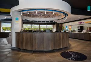 a lobby of a restaurant with a reception counter at Tru By Hilton Novi Detroit in Novi