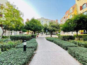 a walkway in a park with trees and buildings at Premium Studio I Discovery Gardens in Dubai