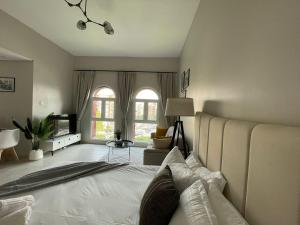 a bedroom with a large bed and a living room at Premium Studio I Discovery Gardens in Dubai