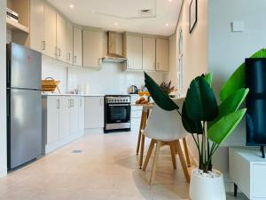 a kitchen with white cabinets and a table with a plant at Premium Studio I Discovery Gardens in Dubai