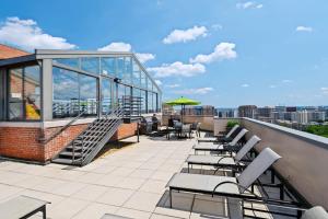 a patio with chairs and tables on a roof at Gorgeous Apt with Rooftop City View @Pentagon City in Arlington