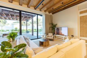 sala de estar con muebles blancos y ventana grande en Maysan Doha, LXR Hotels & Resorts, en Doha